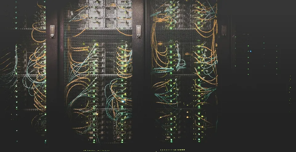 Server racks with network cabling and status lights in a data center.